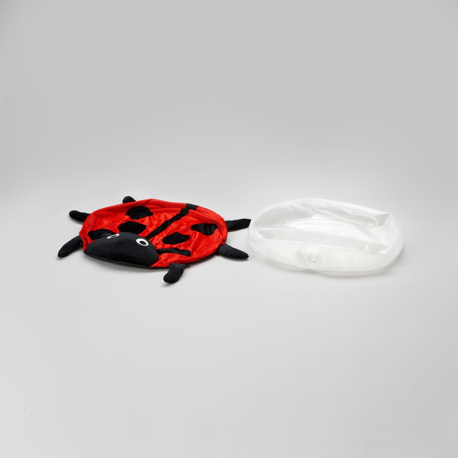 Kissenhülle in Form eines Marienkäfers liegt neben einem Plastikkissen, aus dem die Luft abgelassen wurde.