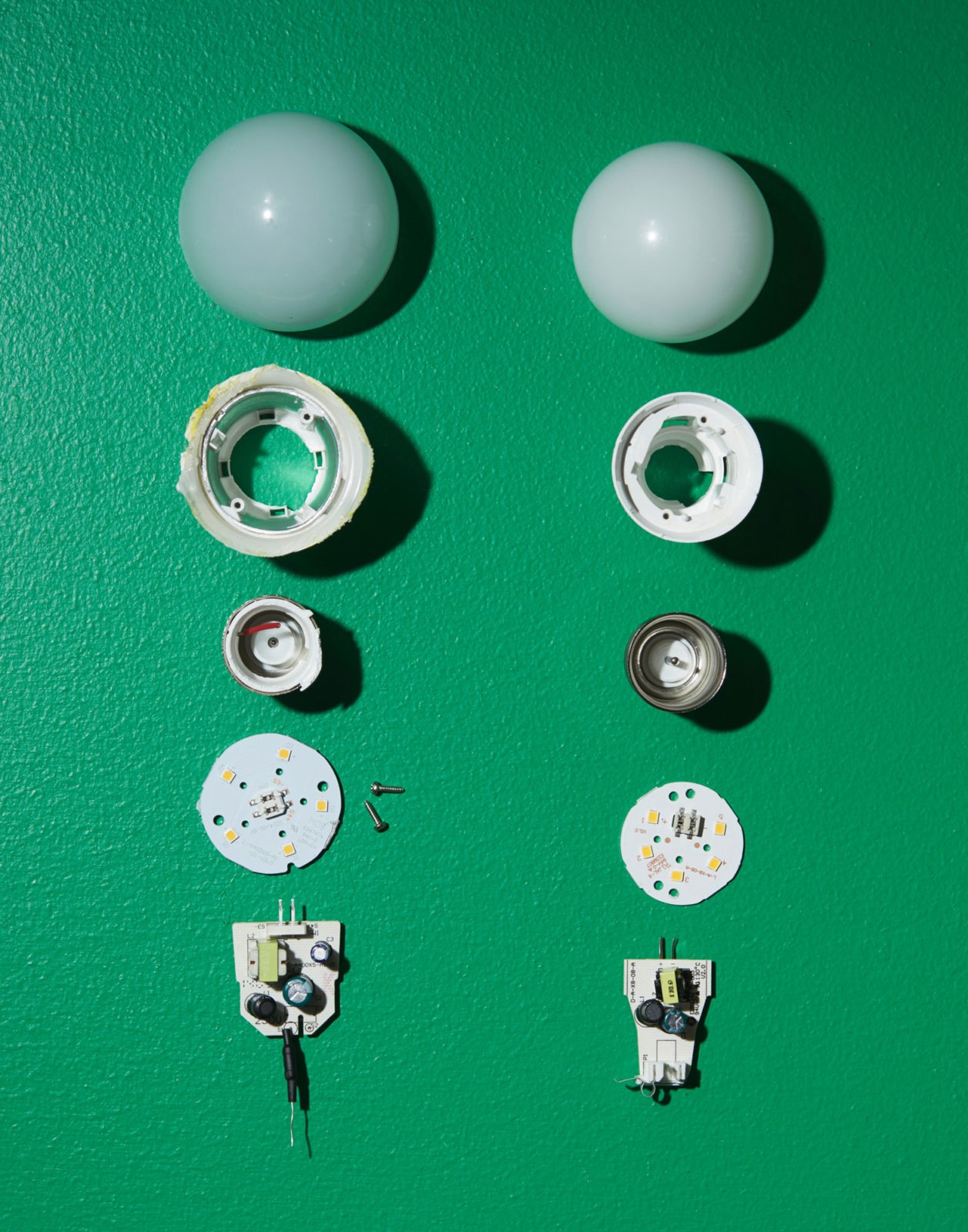 Close-up of parts from two dissassemled LED bulbs.
