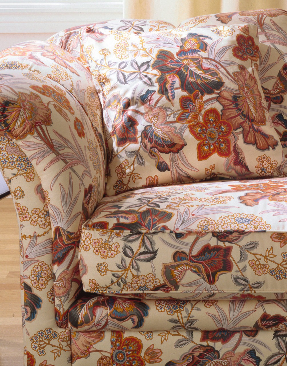 Close-up of sofa with floral pattern in red, blue, yellow and brown at brown.