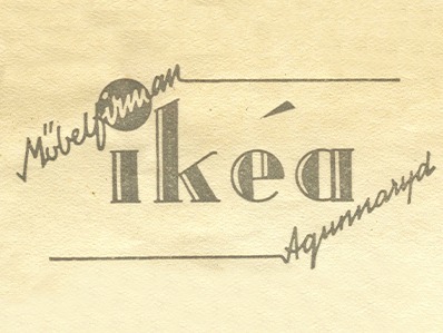 Texten ikéa tryckt med små bokstäver, omgiven av snedställd kursiv text, Möbelfirman till vänster, och Agunnaryd till höger.