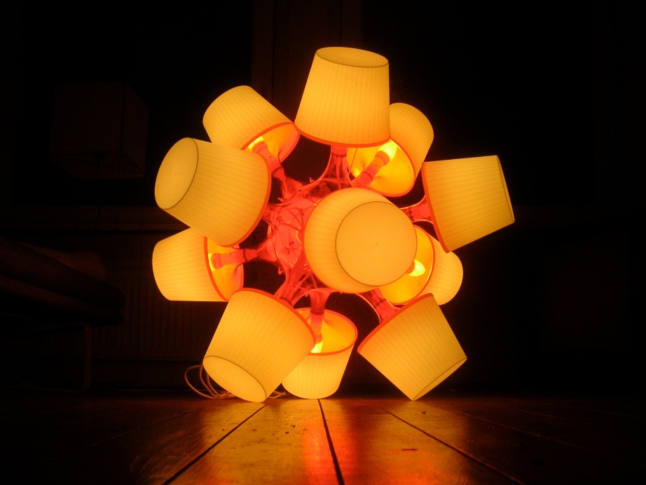 En lampa som heter ”Platonic Suns”. Lampan är designad av Daniel Saakes och skapad av tolv stycken LAMPAN lampor som har limmats ihop vid foten.