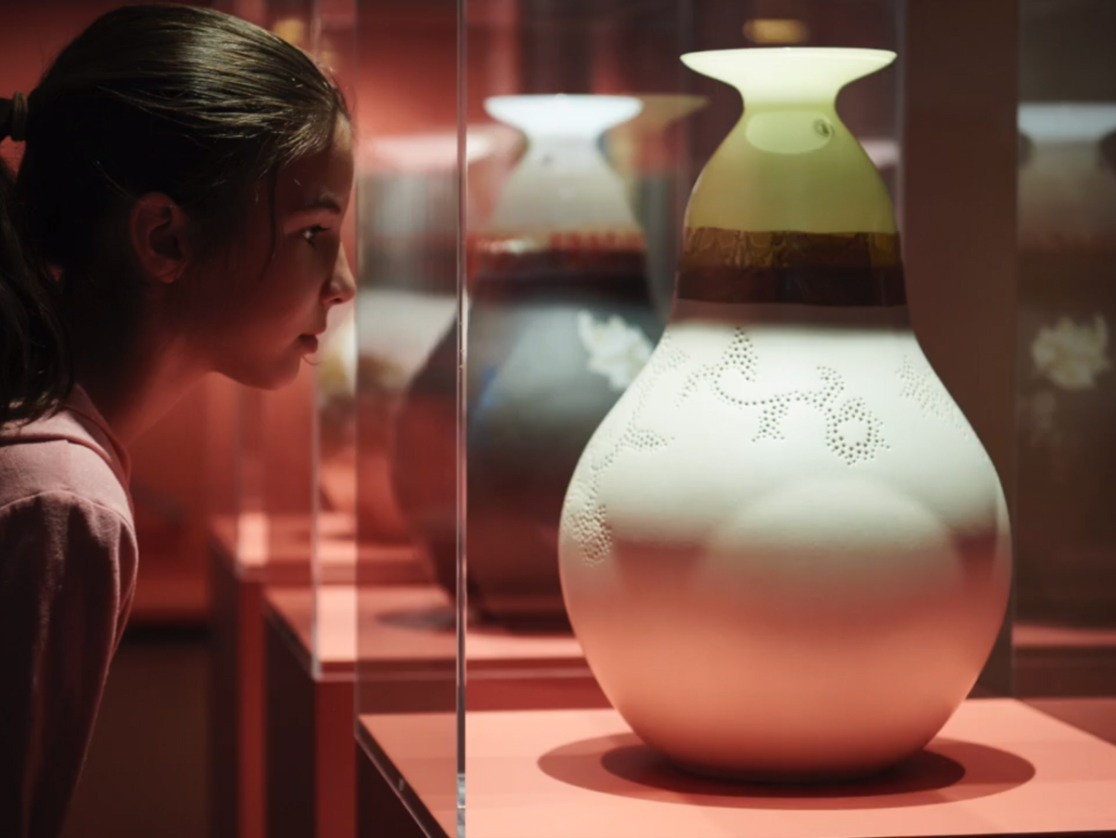 En flicka tittar in i utställningsmontrar med Simulacra-skulpturer som är skapade av två olika IKEA vaser och designade av Bas van Beek.