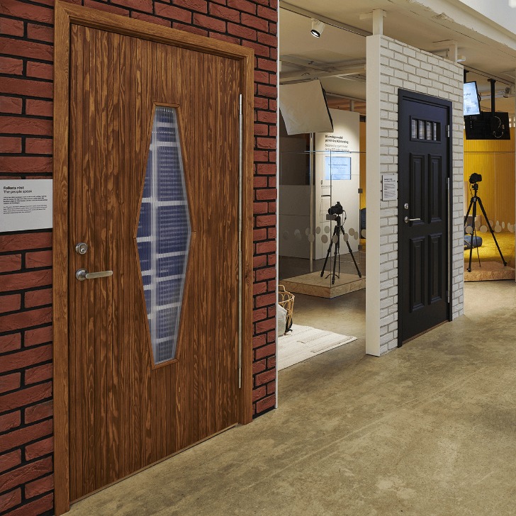 Fake sliding walls with bricks and front doors in different colours, studio backgrounds and tripods with cameras.