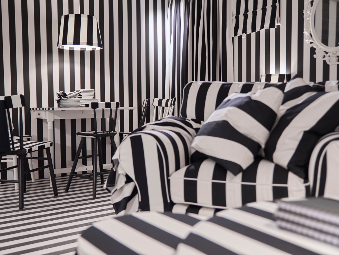 A room where all the furniture is covered with the same striped black and white pattern, as well as the walls and the floor.