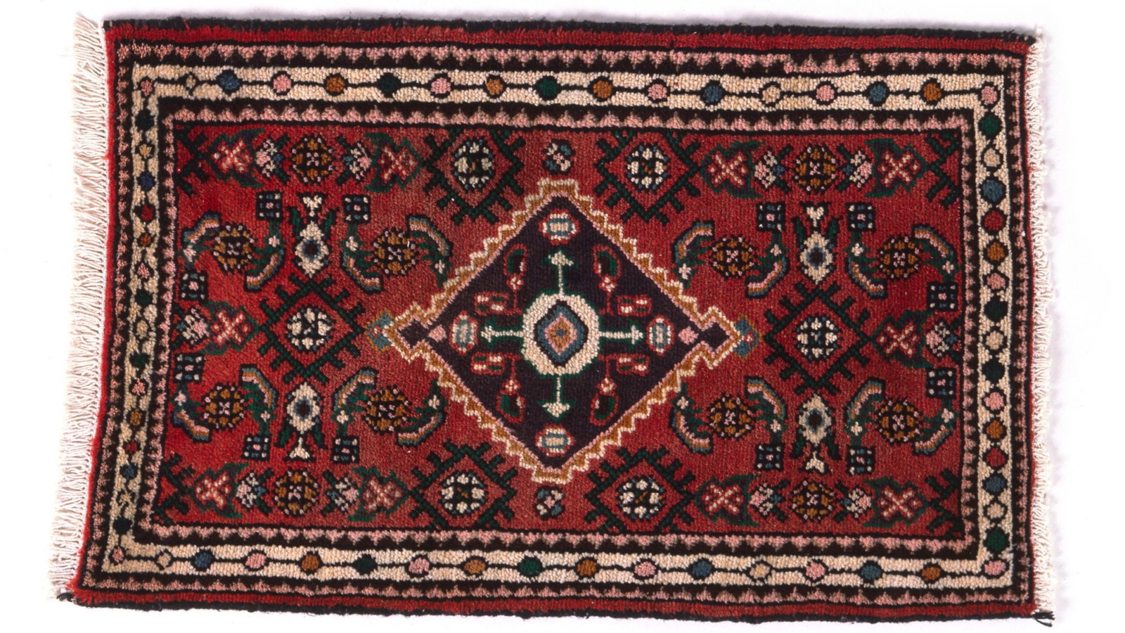 Red Wilton rug, traditional pattern with black, white, pink, blue, brown details.