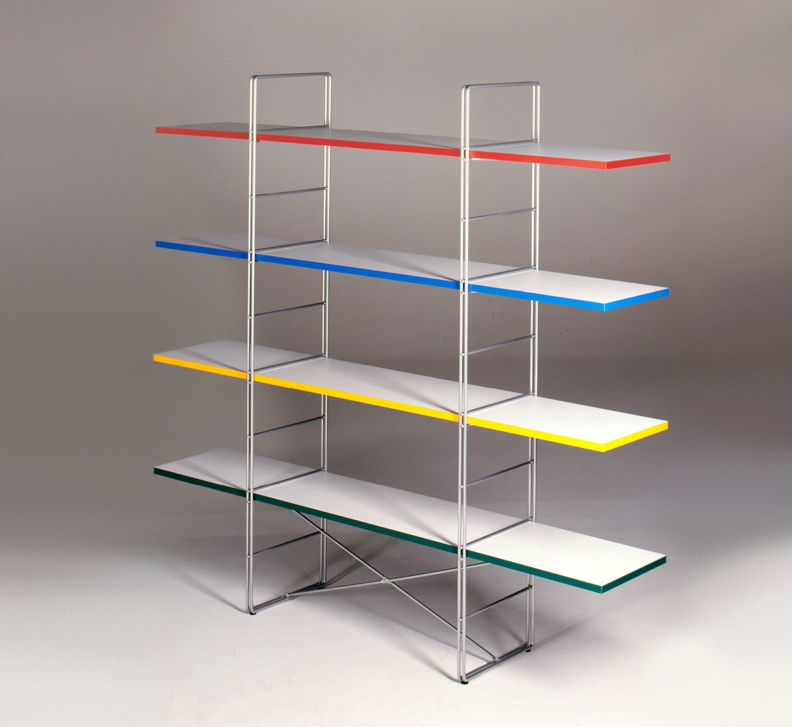 GUIDE shelving unit with wire sides with white shelves that have different coloured edges, red, blue, yellow and green.