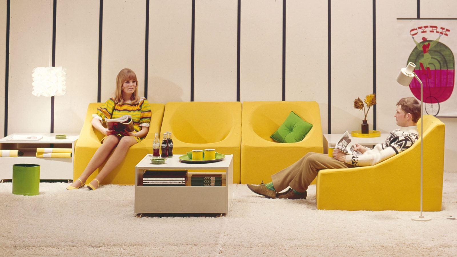 Low, yellow TROFÉ armchairs, like eggcups with straight sides, are placed as a corner sofa on a thick rug.