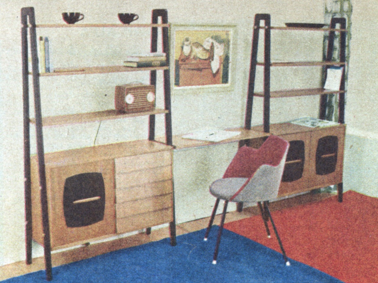 Silla junto a pieza de almacenaje con escritorio en la mitad, en un estilo ligero y funcional. Alfombra roja y azul.