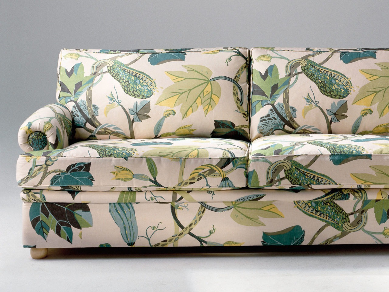 Sofa with bold multi-coloured floral pattern in green and yellow.