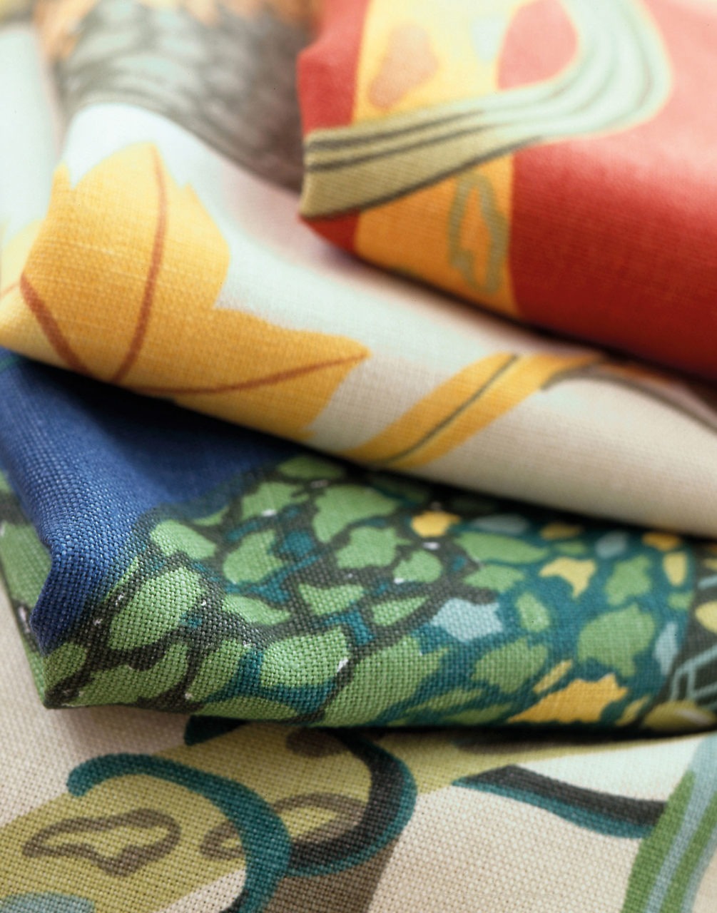 Stacked textiles in bold multi-coloured patterns.