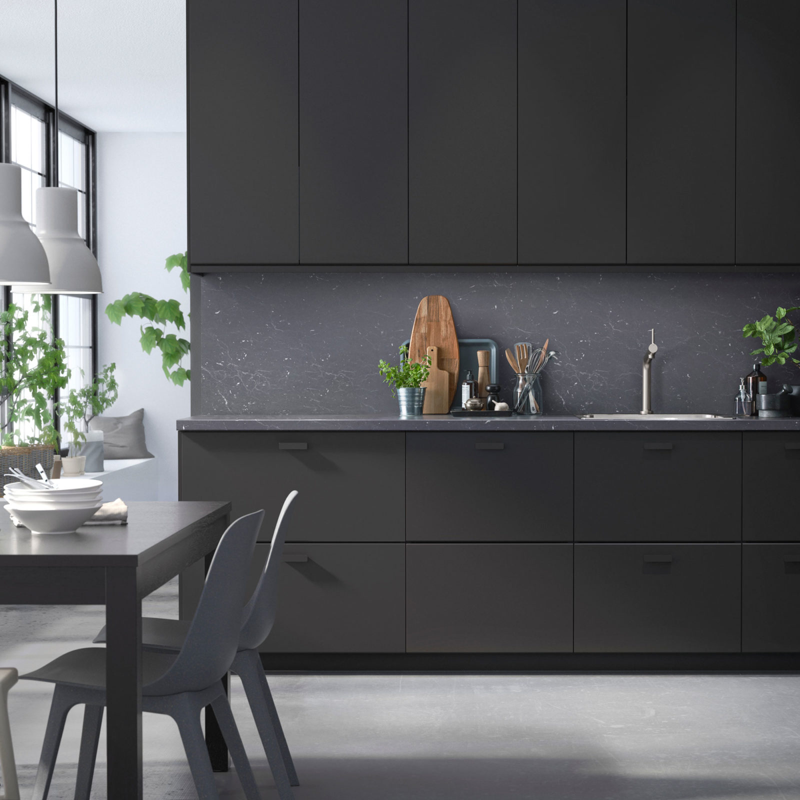Kitchen with matt black fronts with chamfered edges, a dining table and chairs in the foreground, KUNGSBACKA.
