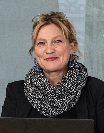 Mia Olsson Tunér, blond kvinna i svart jacka och svartvit-mönstrad sjal.