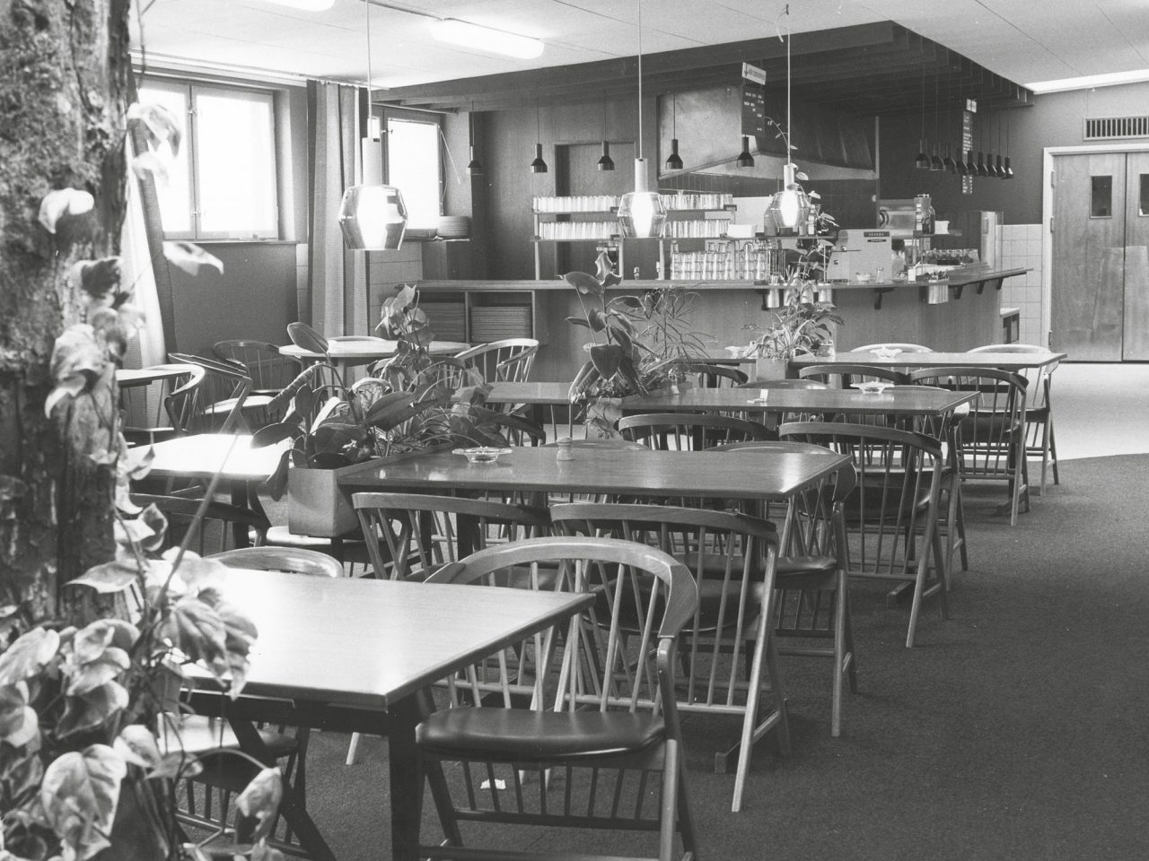 Leeres Restaurant mit Selbstbedienungsbereich und Holzmöbeln im Stil der 1960er.
