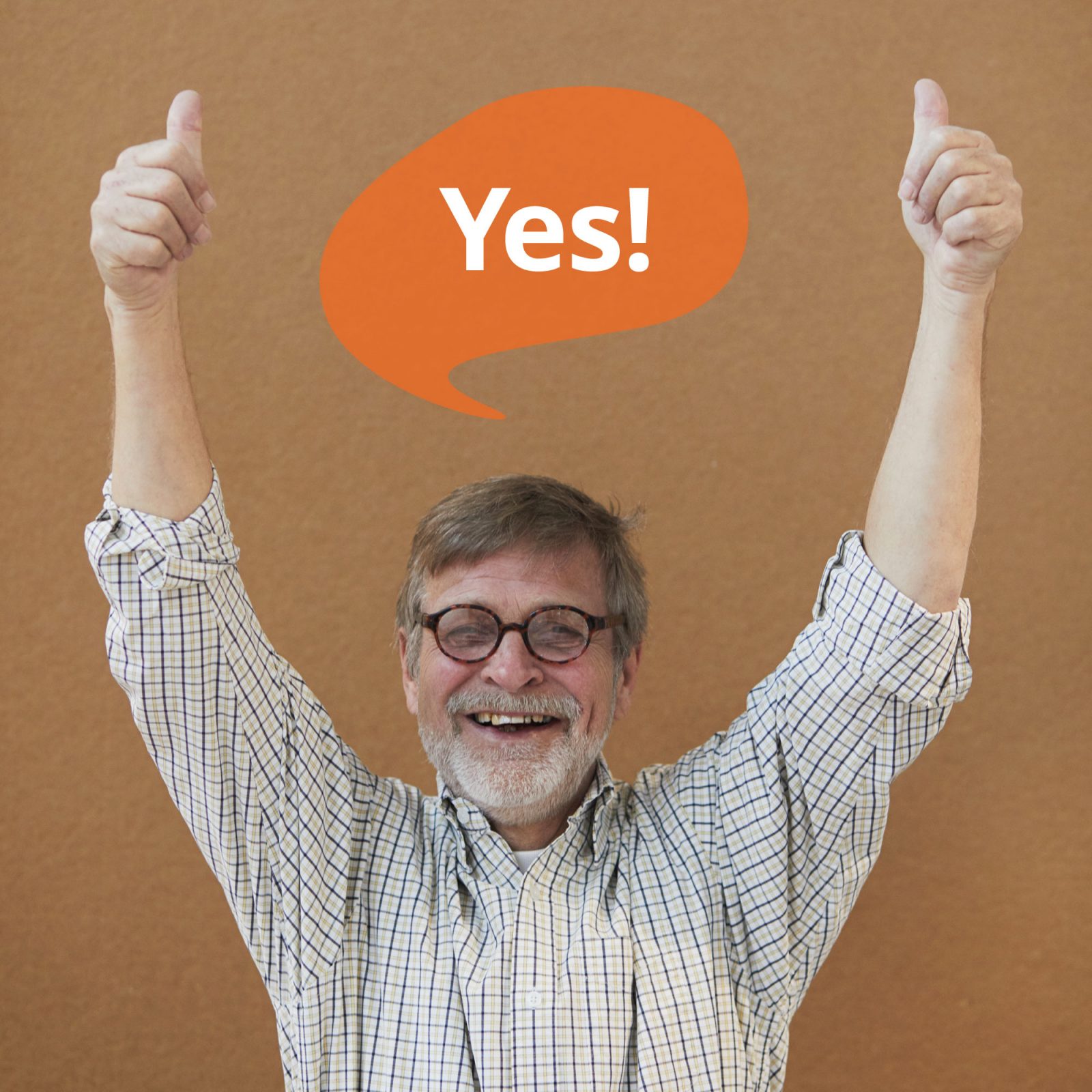 Grey-haired man in check shirt smiles and puts two thumbs up. A speech bubble contains the text 'Yes'.
