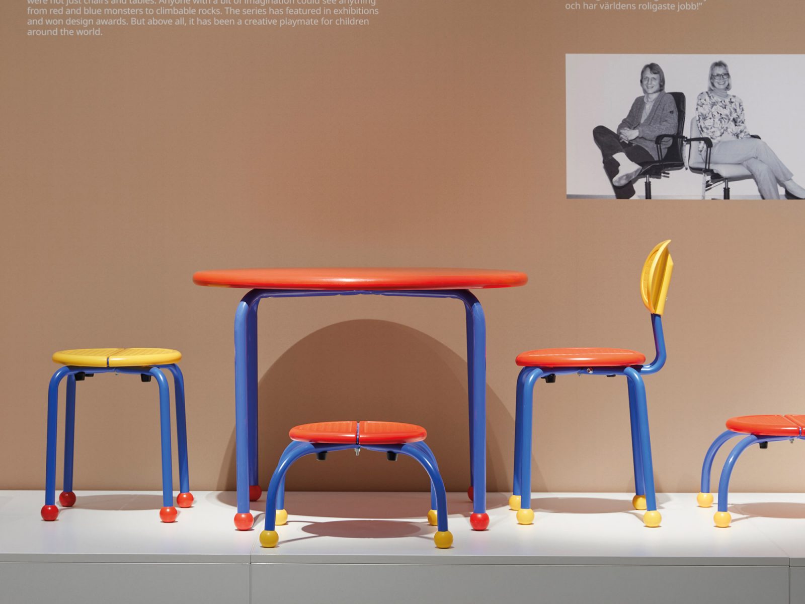 Utställda färgglada barnmöbler, PUZZEL, lågt bord och pallar i gult, rött och blått.