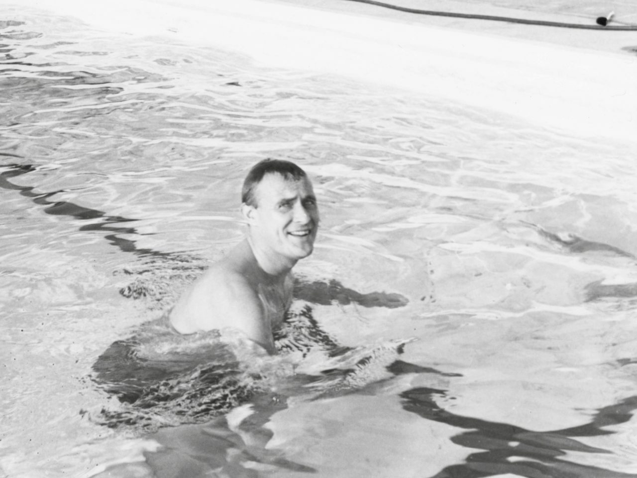 Smiling man in his 30s, Ingvar Kamprad, bathing in swimming pool.