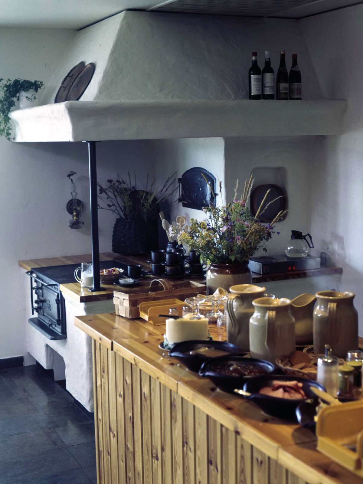 A laid-out buffet next to an old built-in iron stove.