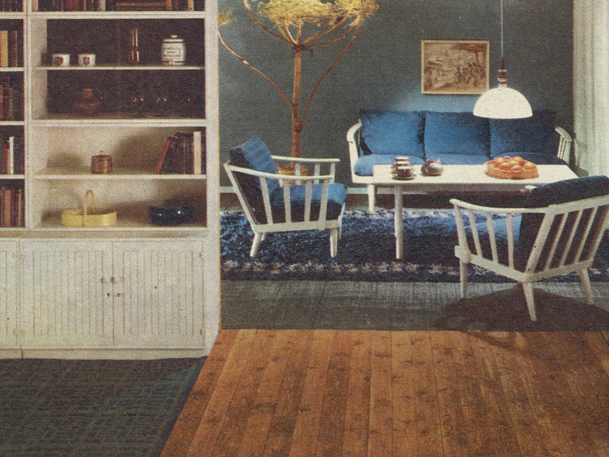 Interiör från IKEA katalog 1965, vit trästol och soffa med blå kuddar och en blå matta från kollektionen LINJE HARMONI.