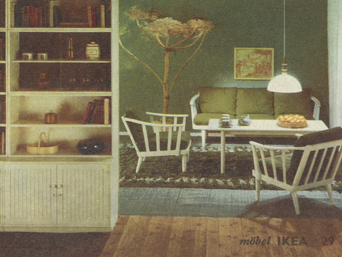 Interiör från IKEA katalog 1965, vit trästol och soffa med gröna kuddar och en grön matta från kollektionen LINJE HARMONI.