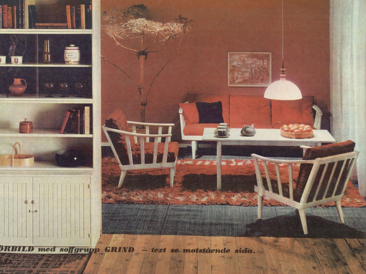 Interiör från IKEA katalog 1965, vit trästol och soffa med röda kuddar och en röd matta från kollektionen LINJE HARMONI.
