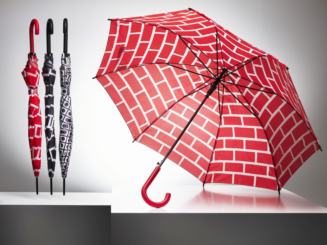 Umbrellas in different graphic patterns in red/white, black/white or grey/white.