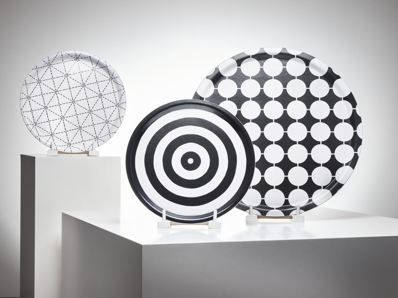 Black/white round trays in different sizes, with varying graphic patterns.