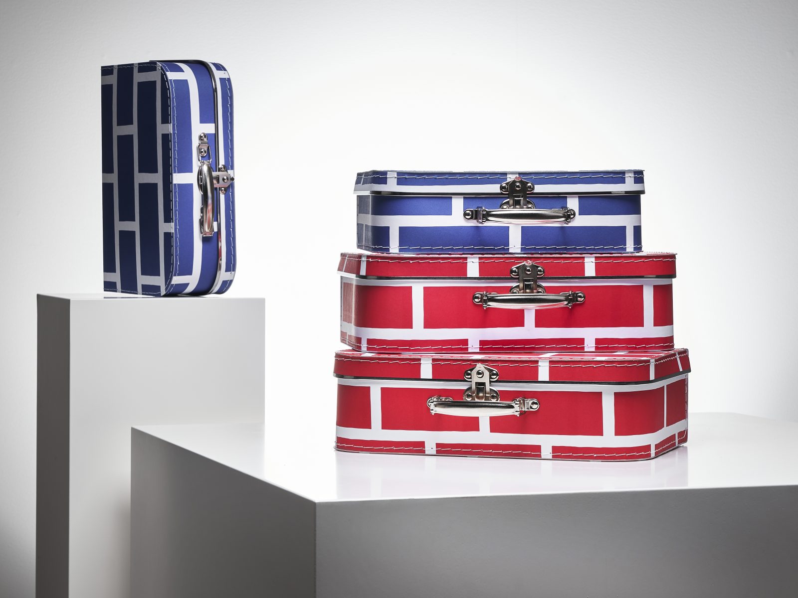Resväskor i olika storlekar med grafiska mönster i blåvitt och rödvitt.