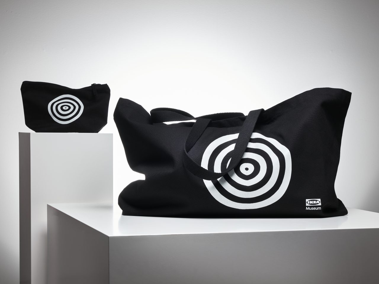 Black accessory bag and oversize tote bag with circle pattern in white.