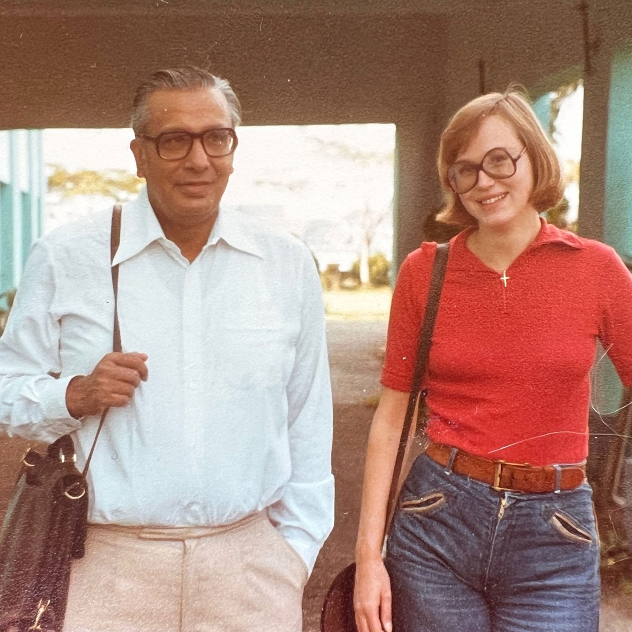 Gråhårig man i svarta glasögon och vit skjorta, Mr. Nath, står med ung kvinna i jeans och röd tröja, Ann-Christin Karlsson.