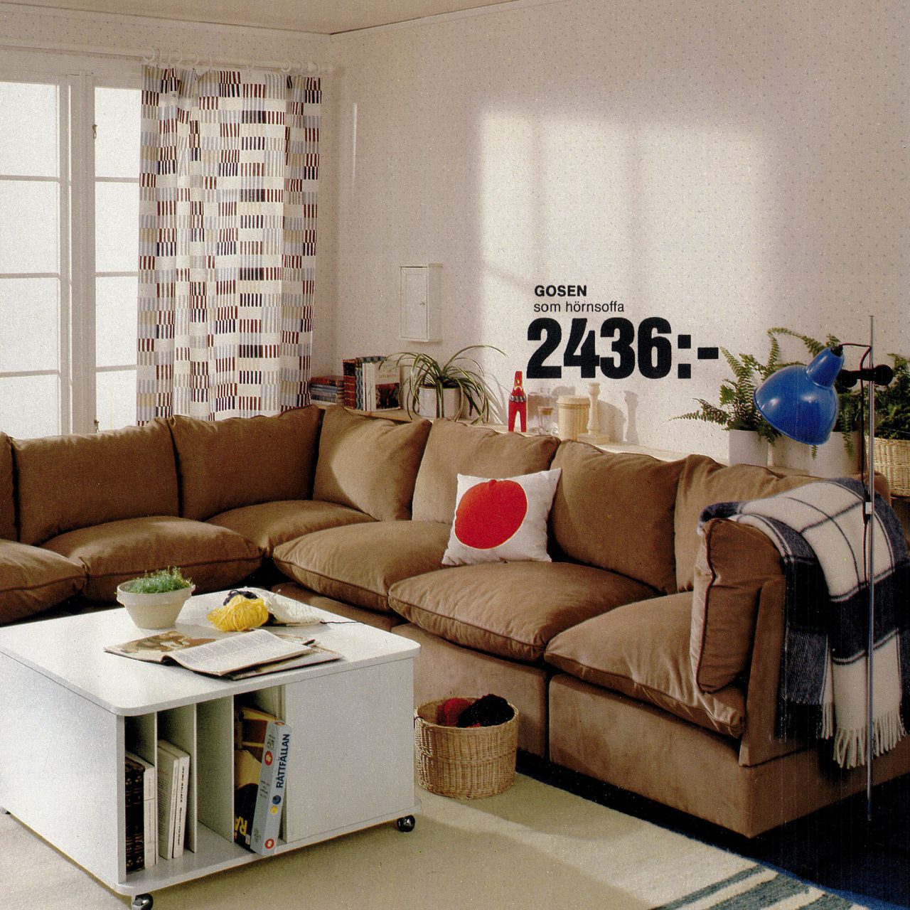 Vardagsrum med beige hörnsoffa i manchester, vitt fyrkantigt soffbord och gardiner i grafiskt mönster.