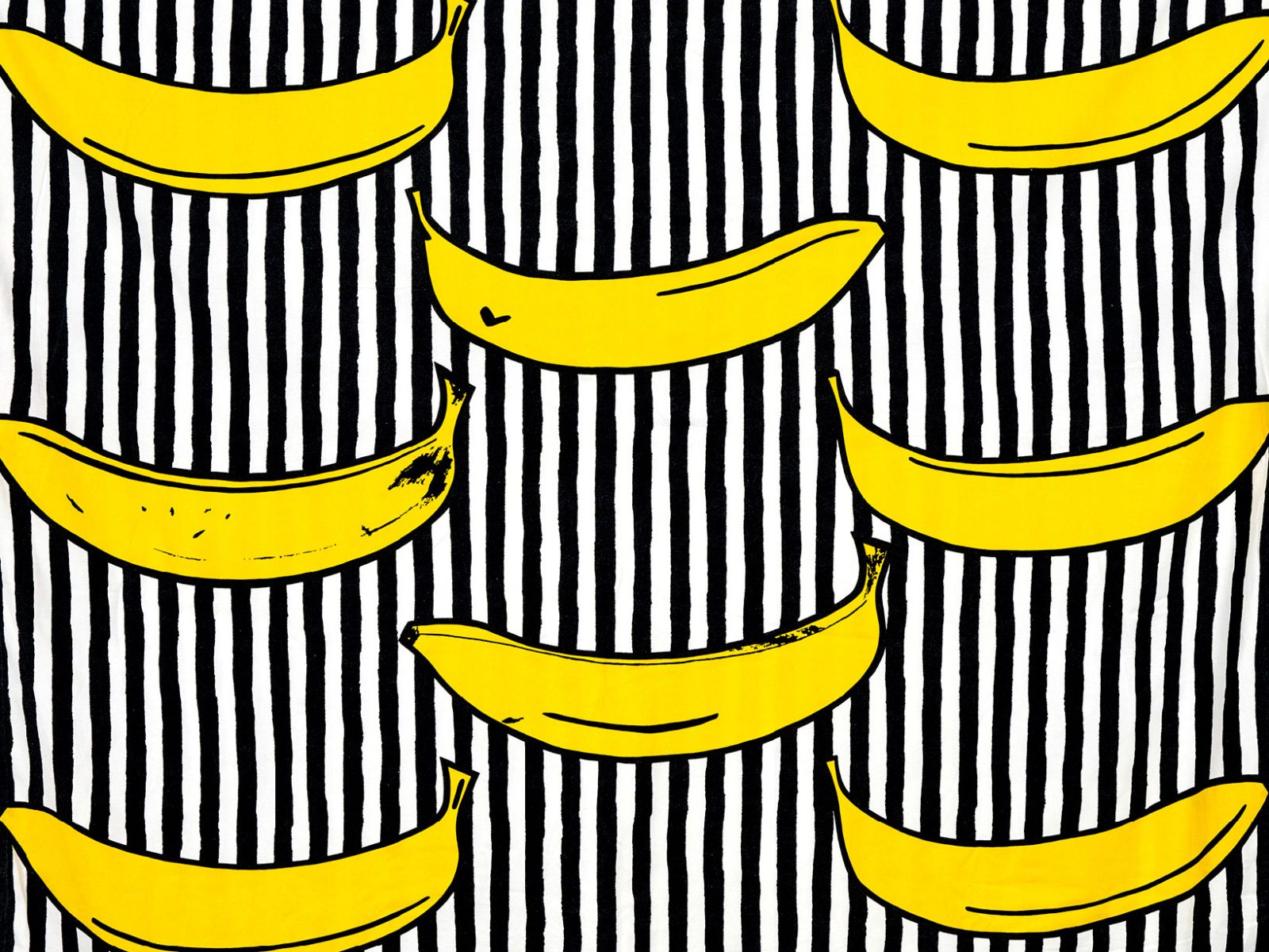 Textile pattern with yellow bananas on a black-and-white striped background.