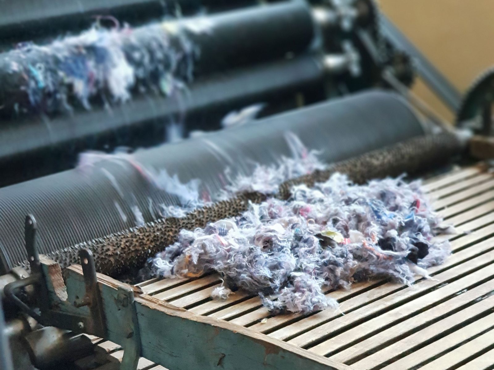 Närbild på maskin som river textil till småbitar.