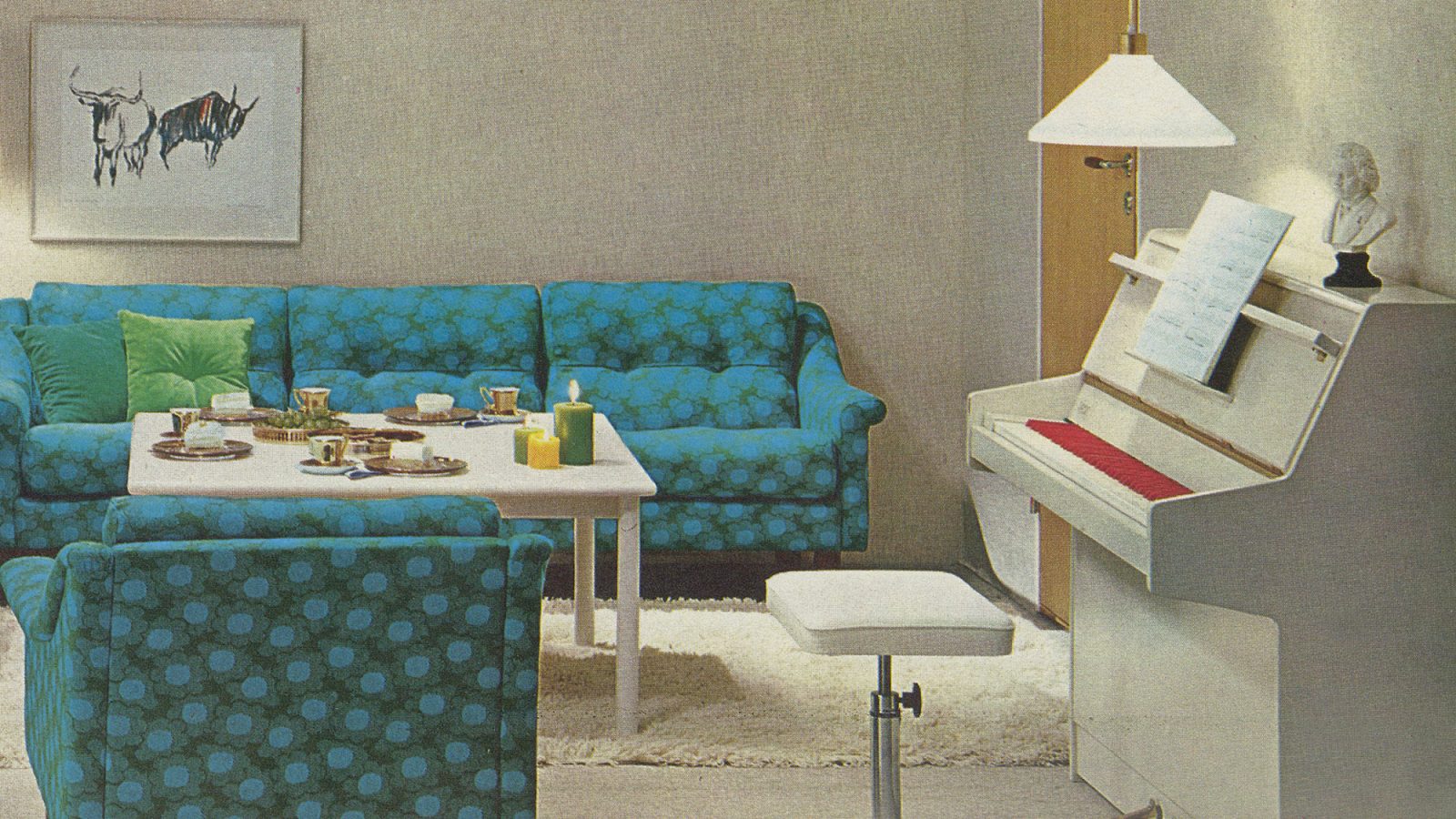 1970s interior with green-turquoise sofa, white rya rug, and white piano with red and white keys.