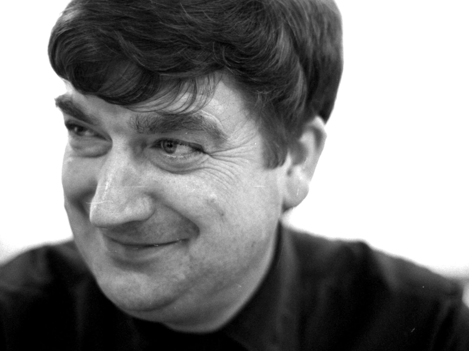 Dark-haired smiling man in a black polo shirt looking slightly to the right, Eric Andersson.