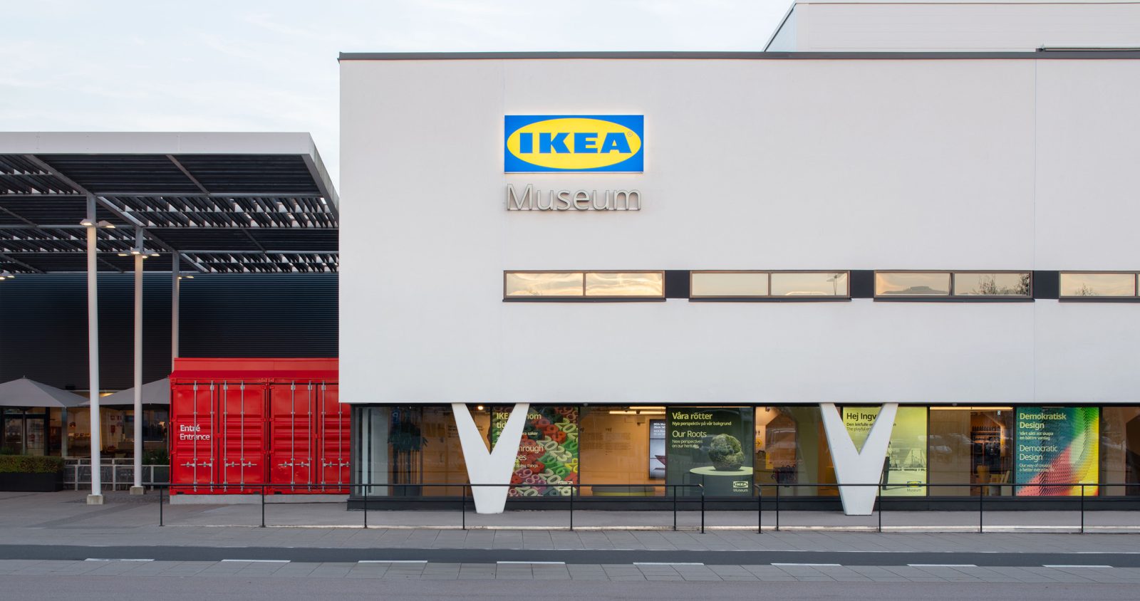 White building with clean lines and v-shaped pillars, sign on facade says IKEA Museum.