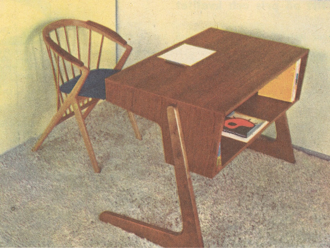 Pin-back chair with armrests and a futuristic desk, model SCRIBO, with L-shaped legs and a built-in shelf on a carpet.