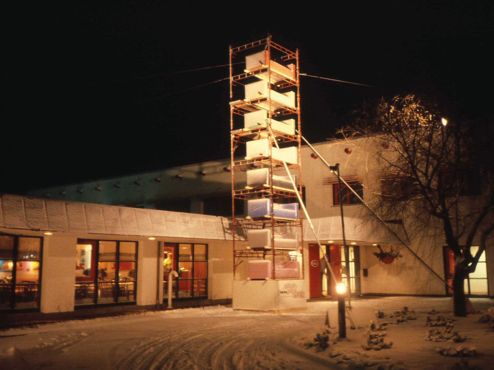 Snow in front of the entrance to IKEA Motel, several KLIPPAN sofas set up on top of each other outside.