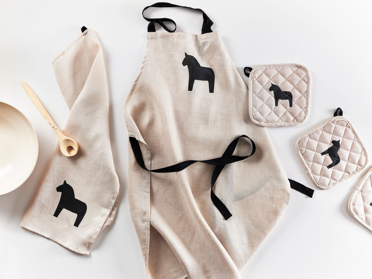 Apron, oven mittens and towels with Swedish dala horse silhouettes.