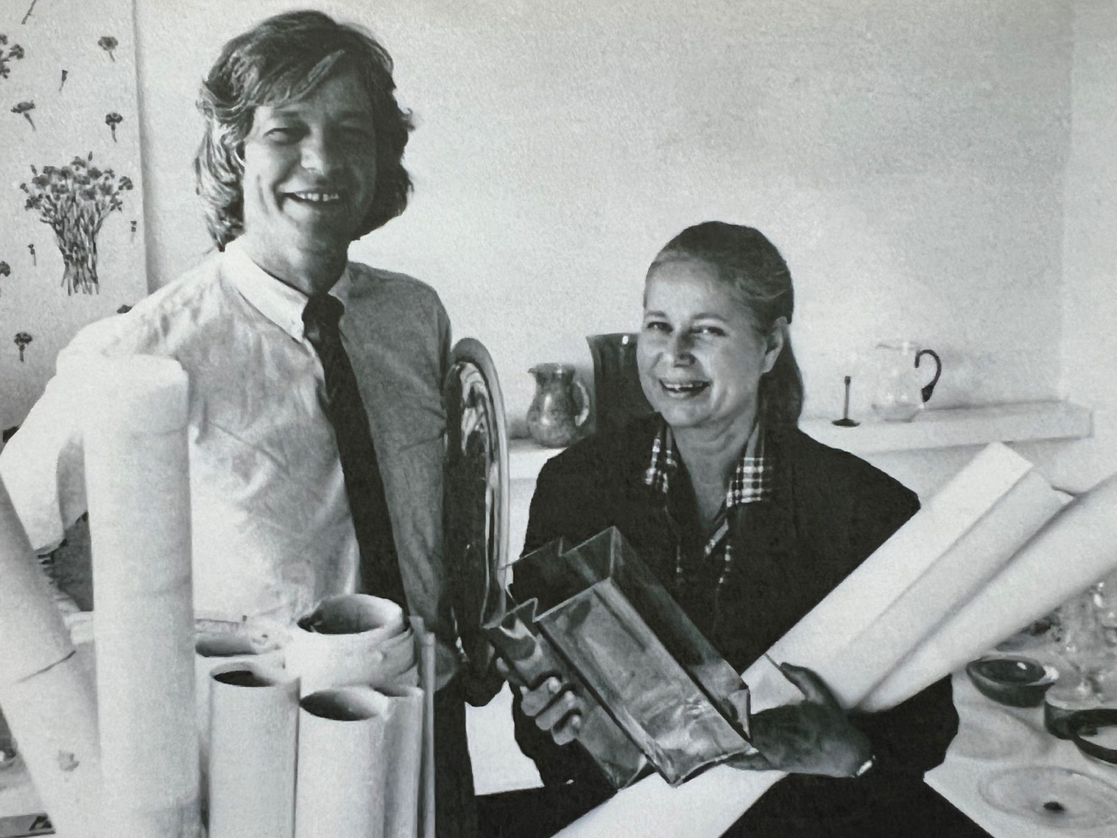 Smiling man with blond curls and smiling woman holding glass vases and posters, Cornelis Janssen and Vivianne Sjölin 1984.