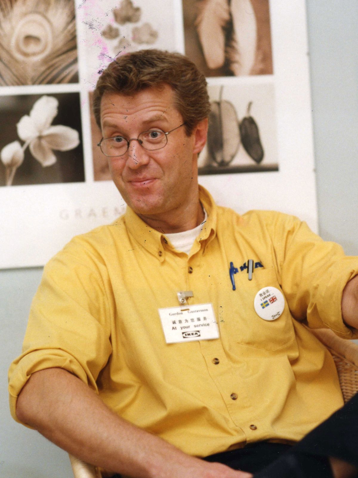 Smiling man in glasses and yellow shirt with the text IKEA. Gordon Gustavsson.