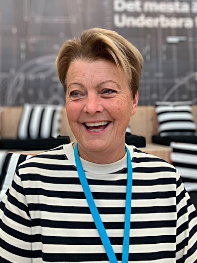 Glad kvinna, Catti Bengtsson, med svartvitrandig tröja och ljust kort hår.