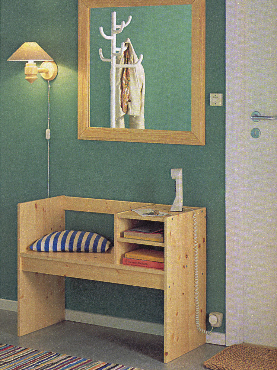 White telephone on the RELING hall furniture with a seat with a black and white striped cushion.