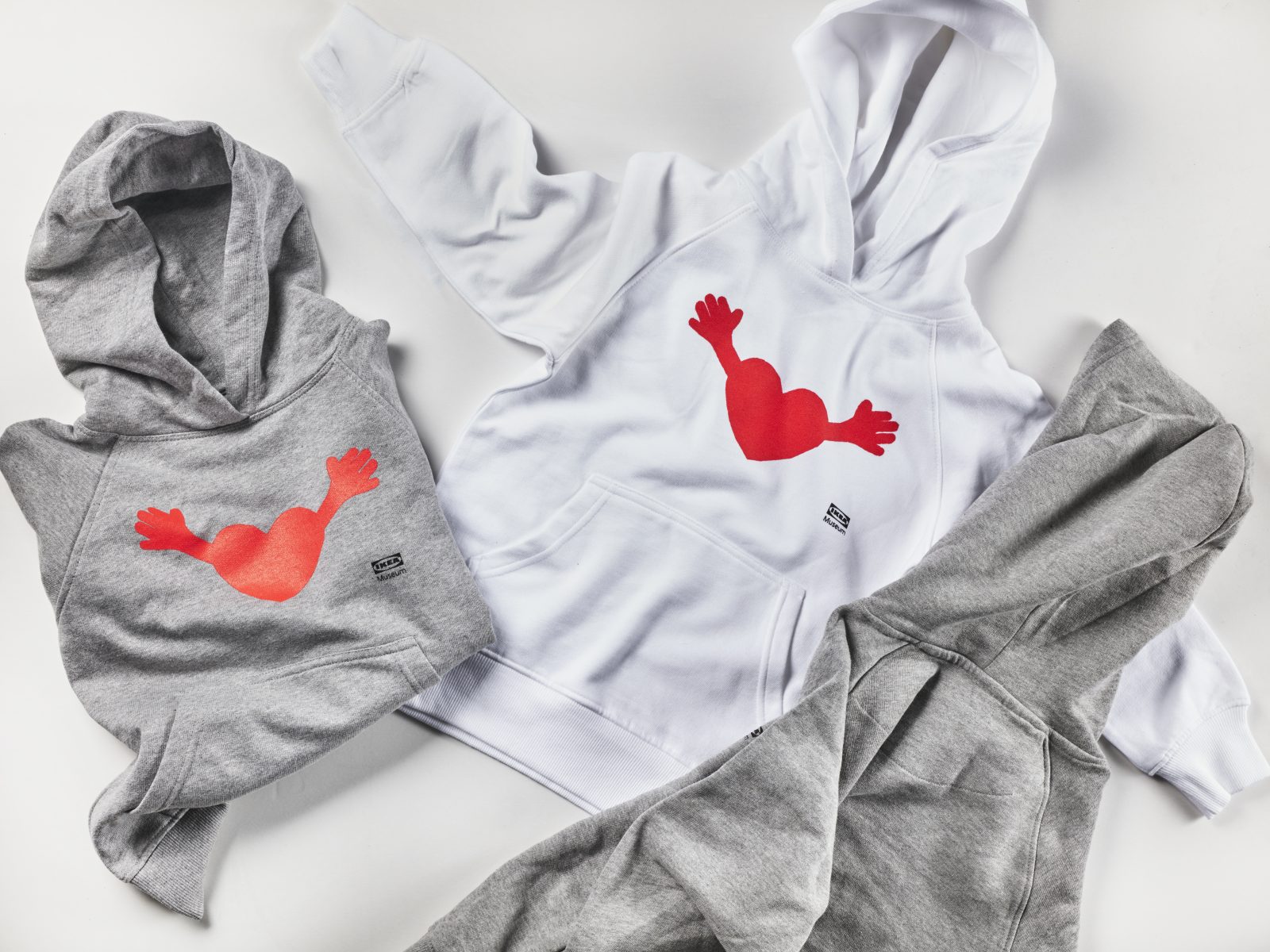 Vita och grå hoodies med ett mönster av en kudde i form av ett rött hjärta med armar.