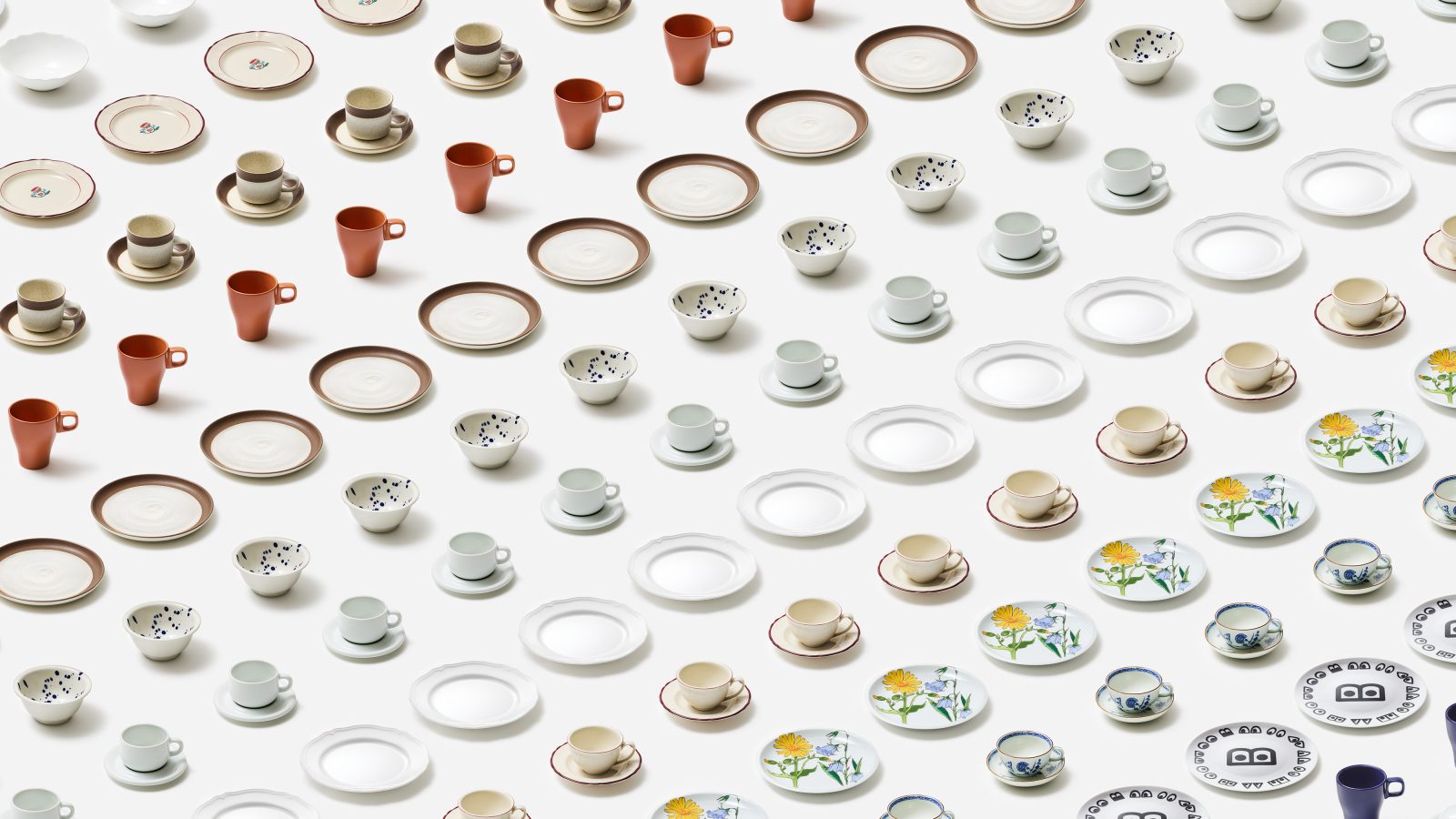 An array of variously patterned and colored cups, saucers, and plates neatly arranged in rows on a white background.