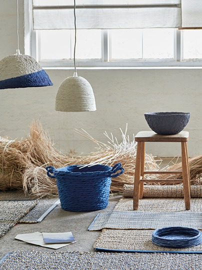 Woven products in indigo, beige and white placed on woven mats.