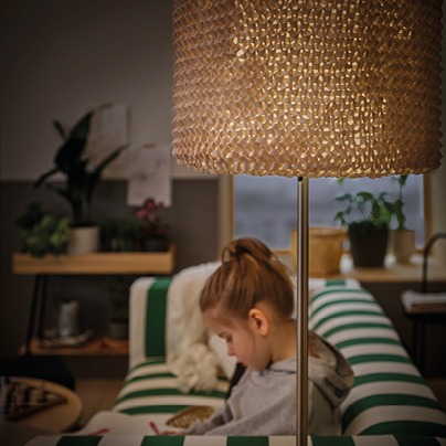 Hand-knitted lamp shade LERGRYN shines a warm, soft light on a girl reading.