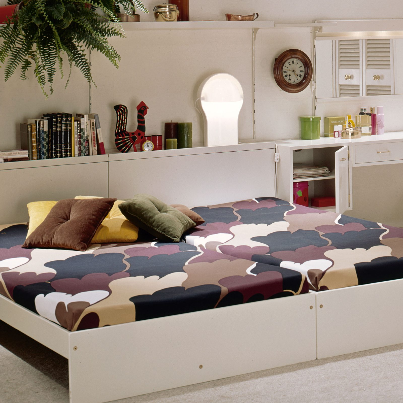 1970s style bedroom, a white low double bed with bedspread in paw-like pattern in brown, black and beige.