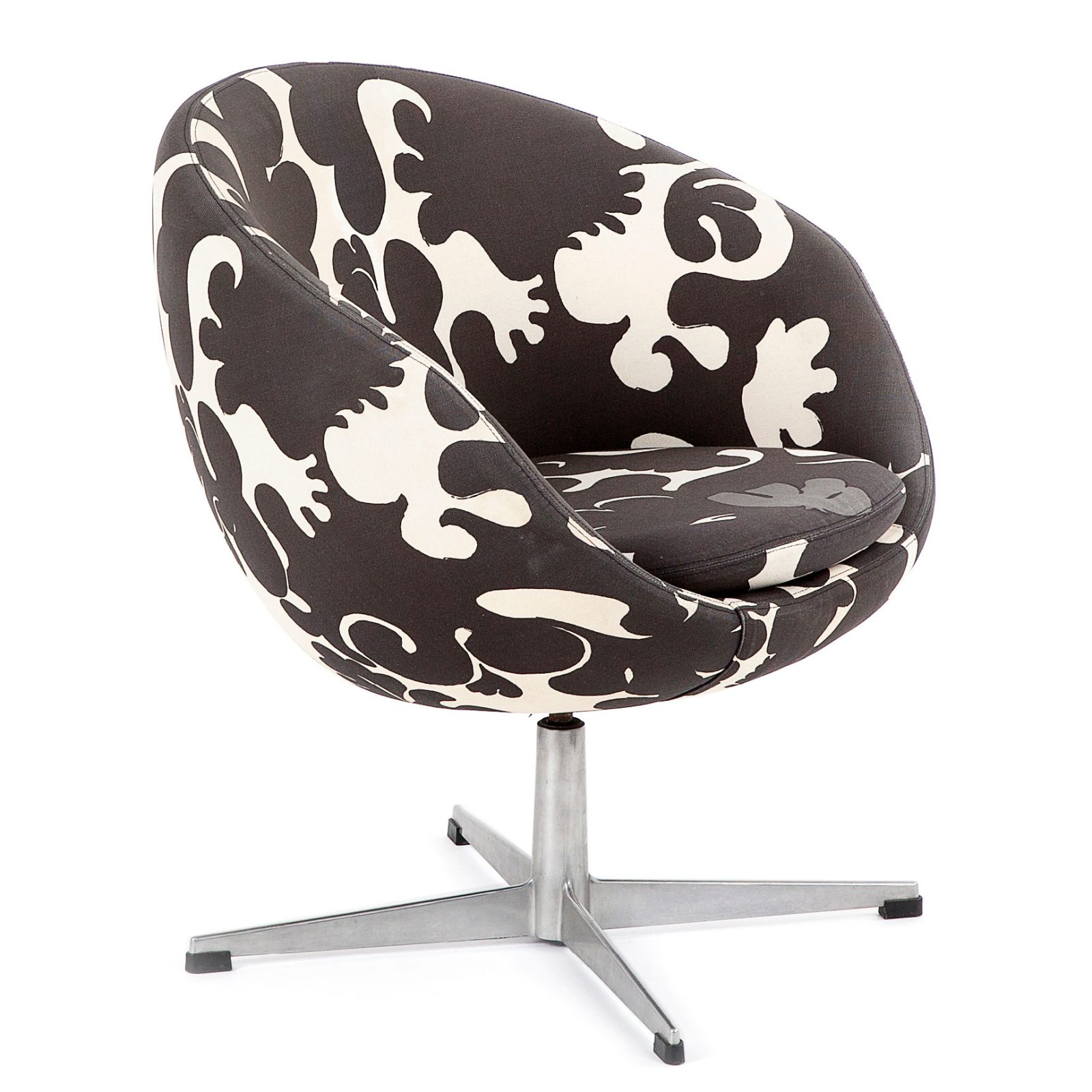 Swivel chair upholstered in psychedelic black and white pattern.