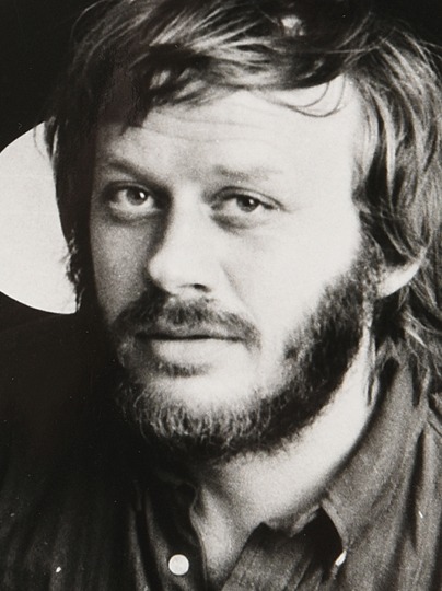 Young bearded man with tousled hair.