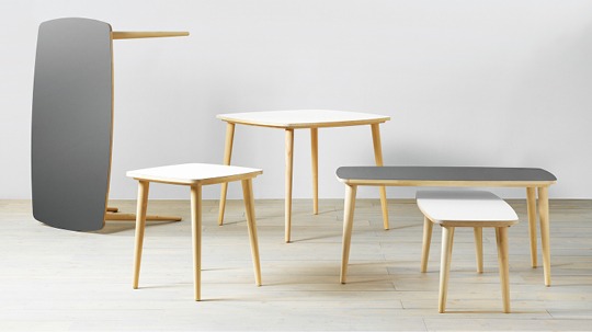Simple wooden tables with white or grey tops.